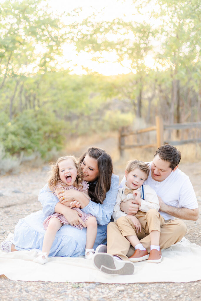 Utah family cuddling together at sunset in Alpine Utah, captured by a Provo Utah photographer during a playful outdoor session.
