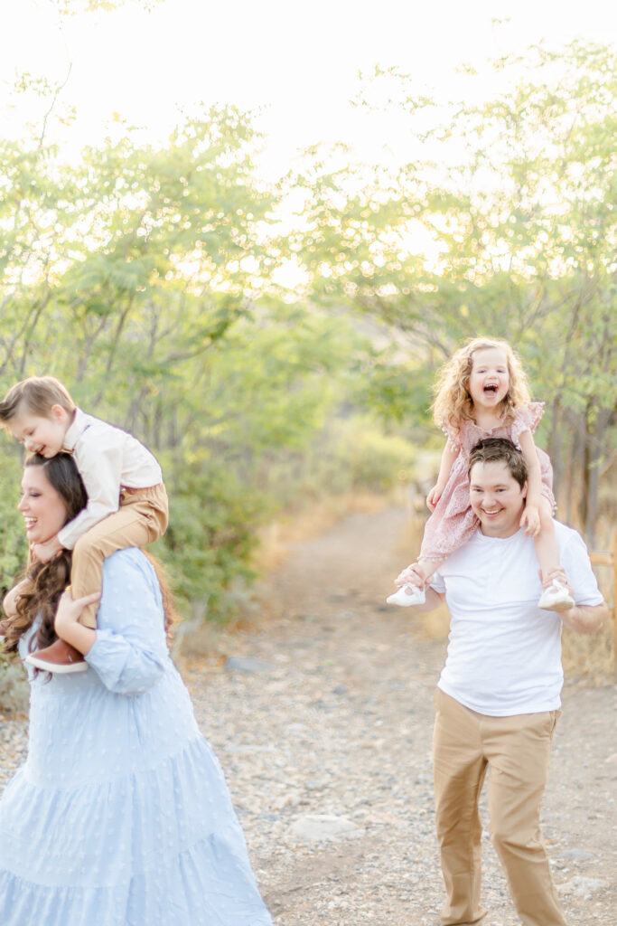 Parents holding their children in a mountain field in Alpine Utah, photographed by a Provo Utah photographer specializing in family portraits.”