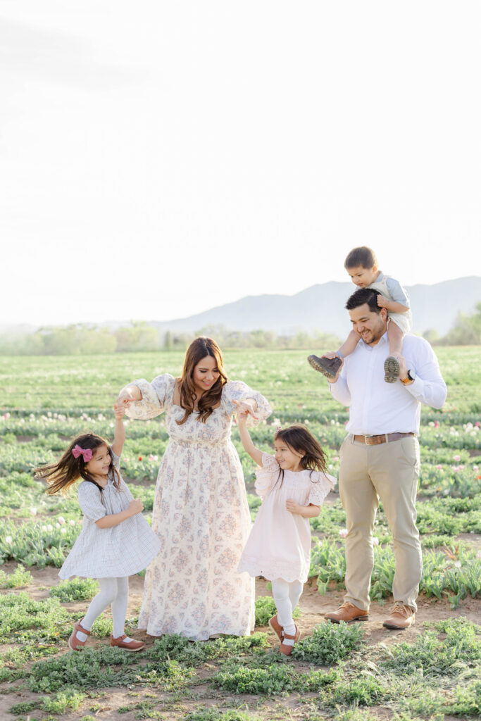 A family plays together and twin girls twirl among blooming tulips in Utah