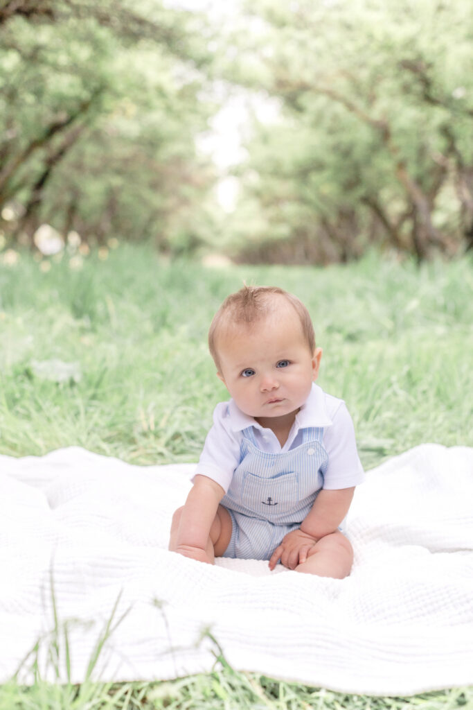 A baby boy makes a silly face in a Utah County orchard family photo session.