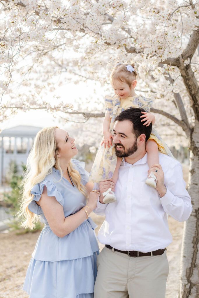 A family laughs together under the cherry blossoms in Utah